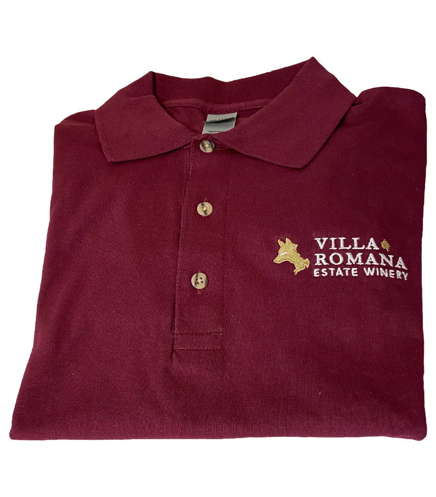 A maroon-coloured red jersey knit cotton polo shirt, with 3 wood tone buttons and a collar, embroidered with the Villa Romana Estate Winery logo and wordmark